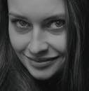 pexels-photo-12064379-12064379 Close-up black and white portrait of a smiling woman with expressive eyes.
